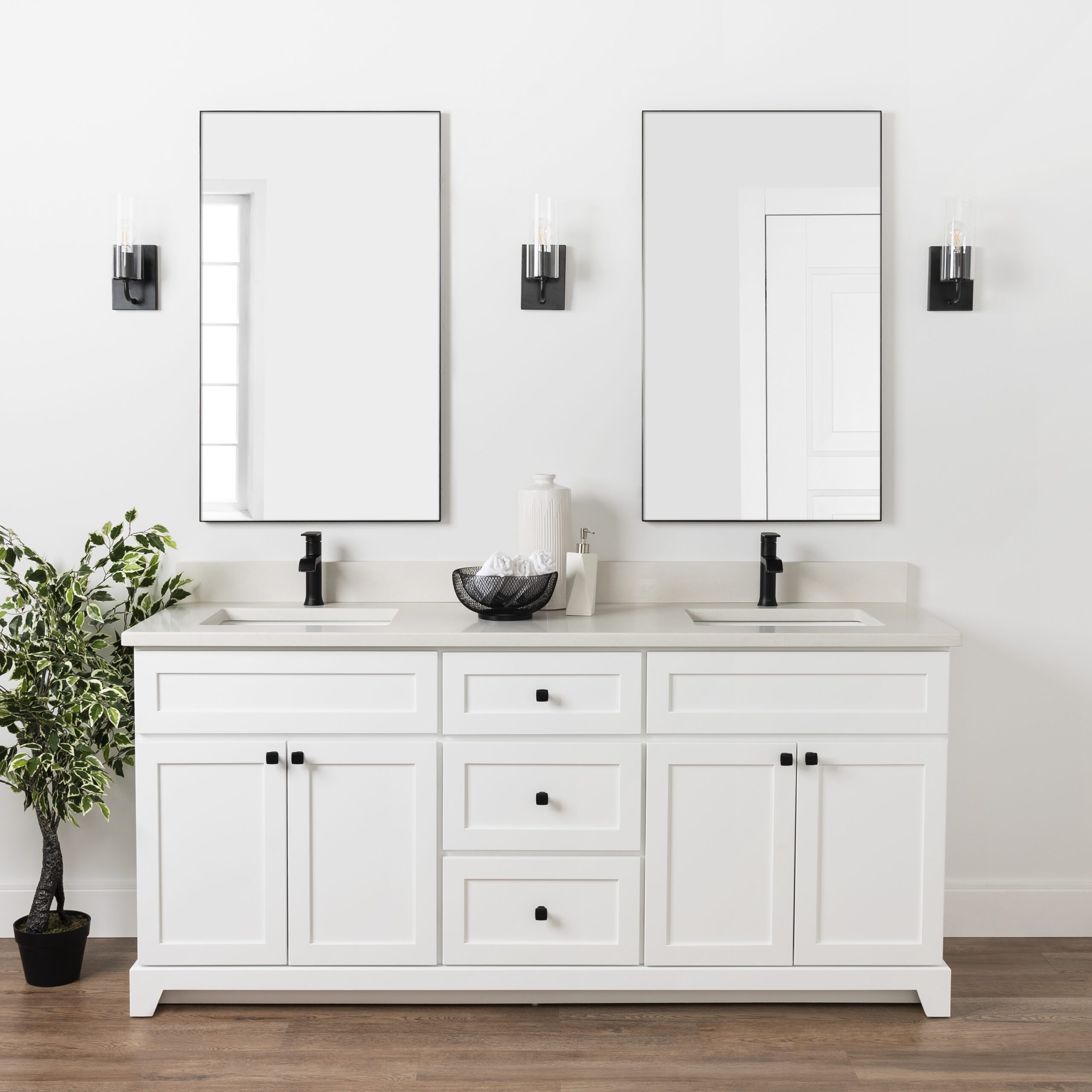 A white bathroom vanity with two mirrors and a plant.